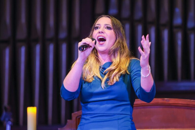 A vocalist performs in front of the organ pipes