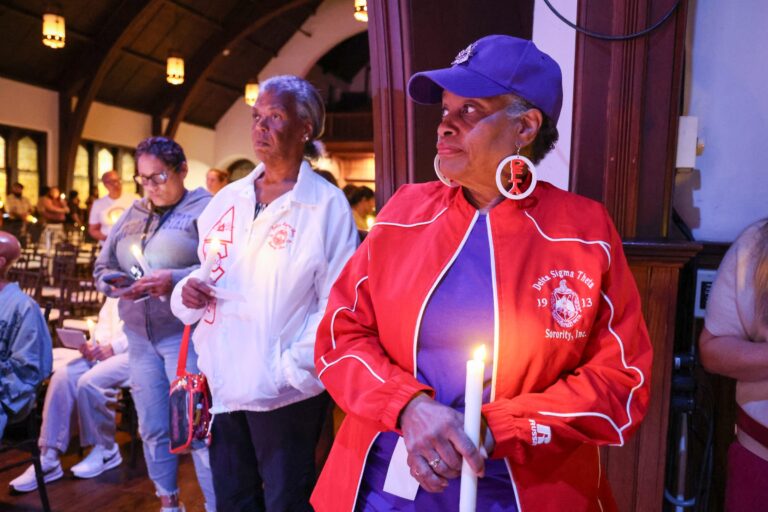 Candle bearers wait their turn beside the seated audience
