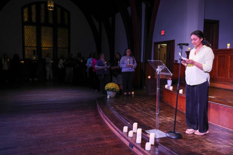 A speaker at the podium, with candles along the stage