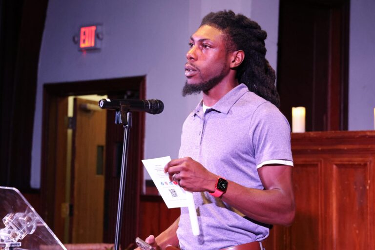A young man speaks at the microphone