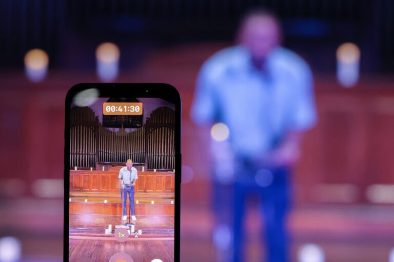 An attendee records a speaker on a phone