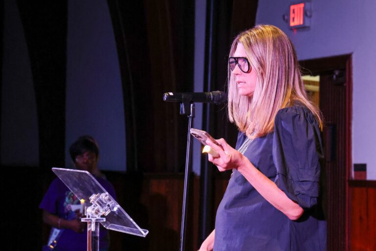 A speaker reads from a card at the microphone