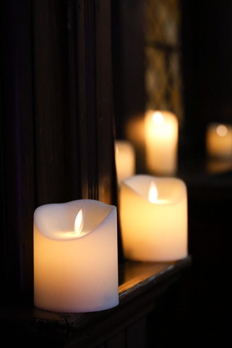 Candles glowing in front of a window