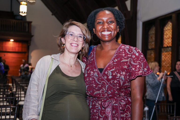 Two attendees smile together after the program